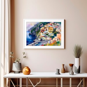May include: Watercolour painting of a colourful Italian village built on a cliffside overlooking the ocean. The buildings are painted in shades of yellow, orange, red, and pink, with green trees and bushes growing around them. The ocean is a deep blue, and the sky is a light blue with white clouds.