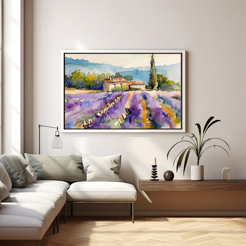 K&ouml;nnte beinhalten: Ein Aquarellbild eines Lavendelfeldes mit einem kleinen Haus in der Ferne. Das Bild ist in einem wei&szlig;en Rahmen gerahmt und h&auml;ngt an einer wei&szlig;en Wand.