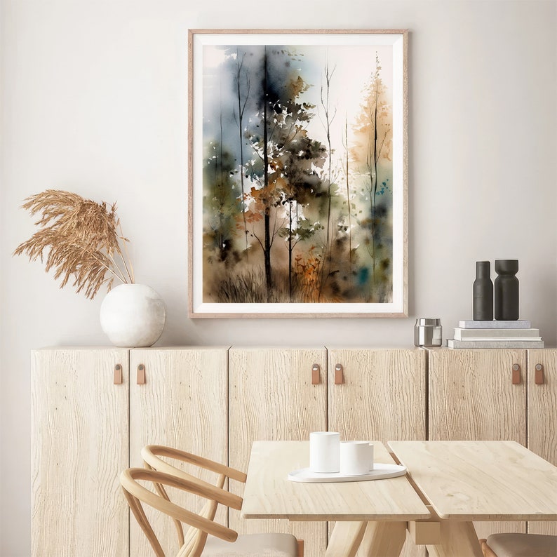 May include: A watercolor painting of a forest scene with tall trees in shades of brown, green, and blue. The painting is framed in a light wood frame and hangs on a white wall.