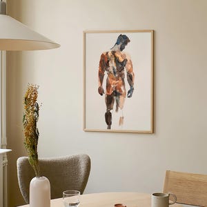 K&ouml;nnte beinhalten: Ein gerahmtes Aquarellbild eines nackten Mannes, der mit dem R&uuml;cken zum Betrachter steht. Das Bild ist in Braun-, Orange- und Blaut&ouml;nen gehalten. Das Bild h&auml;ngt an einer hellbeigen Wand in einem Raum mit einem Holztisch und St&uuml;hlen.