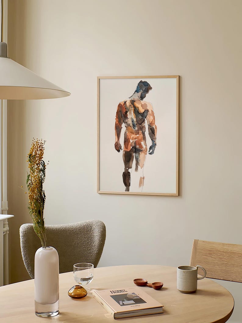 K&ouml;nnte beinhalten: Ein gerahmtes Aquarellbild eines nackten Mannes, der mit dem R&uuml;cken zum Betrachter steht. Das Bild ist in Braun-, Orange- und Blaut&ouml;nen gehalten. Das Bild h&auml;ngt an einer hellbeigen Wand in einem Raum mit einem Holztisch und St&uuml;hlen.