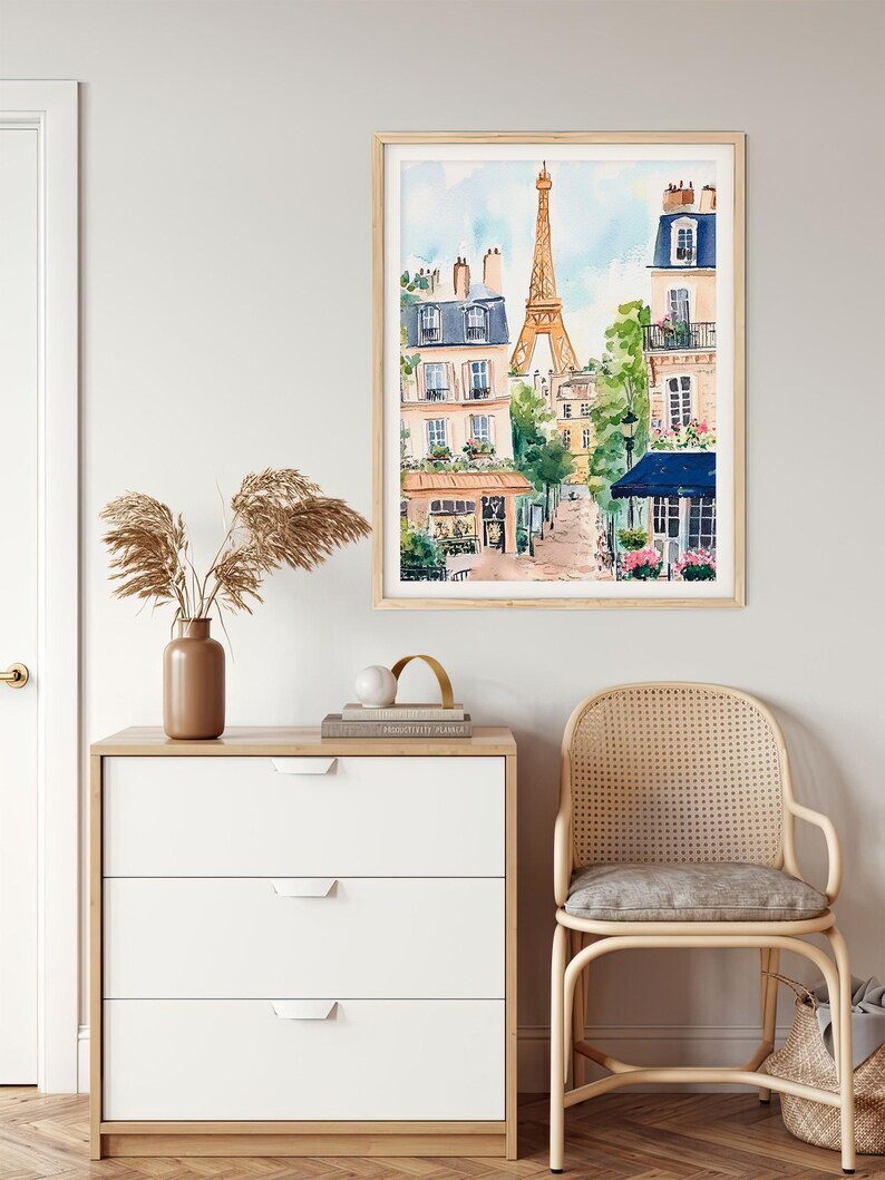 May include: A watercolour painting depicting a Parisian street scene with the Eiffel Tower in the background. The painting features buildings with balconies, trees, and a cafe with a blue awning.