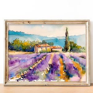 K&ouml;nnte beinhalten: Aquarellmalerei eines Lavendelfeldes mit einem kleinen Haus und einem hohen Baum im Hintergrund. Das Bild ist in einem hellen Holzrahmen gerahmt.