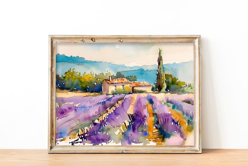 K&ouml;nnte beinhalten: Aquarellmalerei eines Lavendelfeldes mit einem kleinen Haus und einem hohen Baum im Hintergrund. Das Bild ist in einem hellen Holzrahmen gerahmt.