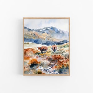 Puede incluir: Pintura acuarela de dos vacas Highland marrones de pie en un campo con una cordillera de montañas en el fondo. El cielo es de un azul claro con nubes blancas. El campo es una mezcla de hierba verde y marrón.