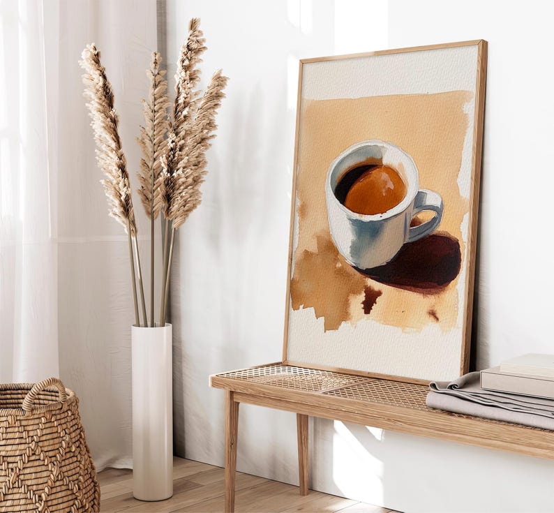 Puede incluir: Una pintura de acuarela enmarcada de una taza de caf&eacute; blanca con caf&eacute; marr&oacute;n sobre un fondo beige.