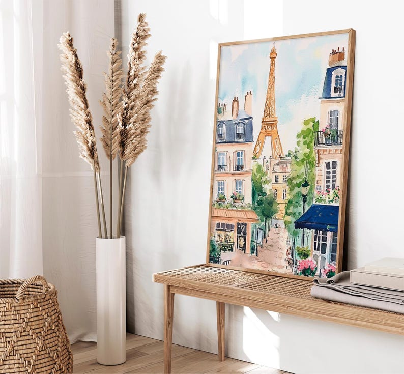 May include: A watercolour painting of a Parisian street scene with the Eiffel Tower in the background. The painting features buildings with balconies, trees, and a cobbled street.