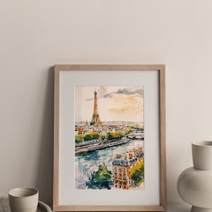 Puede incluir: Una pintura de acuarela enmarcada de la Torre Eiffel en Par&iacute;s, Francia. La pintura muestra la torre desde la distancia, con el r&iacute;o Sena y otros edificios en primer plano. La pintura est&aacute; en un marco de madera claro.