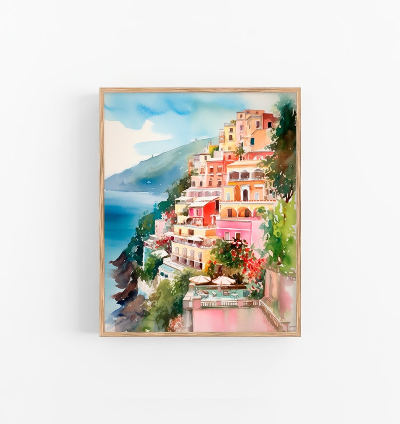 May include: Watercolour painting of colourful buildings on a cliff overlooking the sea. The buildings are painted in shades of pink, yellow, orange, and red. The sea is a deep blue, and the sky is a light blue with white clouds.