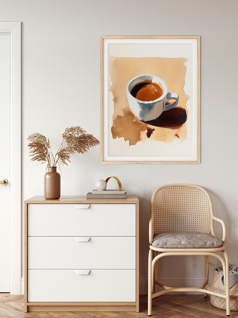 Puede incluir: Una pintura de acuarela de una taza de caf&eacute; blanca con caf&eacute; marr&oacute;n en su interior, sentada sobre una superficie marr&oacute;n. La taza proyecta una sombra sobre la superficie.