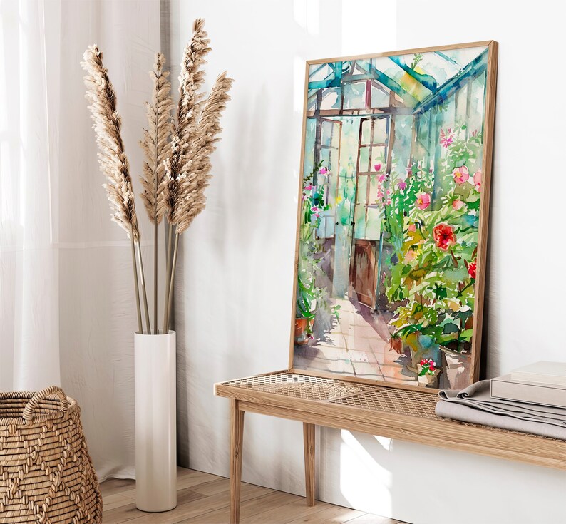 Puede incluir: Una pintura de acuarela de un invernadero con un marco de madera y un techo de vidrio. El invernadero est&aacute; lleno de plantas verdes exuberantes y flores coloridas. La pintura est&aacute; enmarcada en un marco de madera claro y est&aacute; colgada en una pared blanca.
