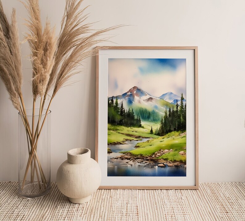 May include: A watercolour painting of a mountain landscape with a river flowing through a valley. The mountains are green and brown, and the sky is blue with white clouds. The river is blue and reflects the sky.