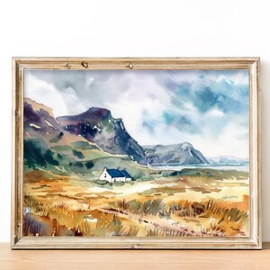 Pu&ograve; includere: Un dipinto ad acquerello di un cottage bianco con un tetto blu in un campo con erba alta. Il cottage &egrave; incastonato in una valle con montagne sullo sfondo. Il cielo &egrave; nuvoloso e blu.