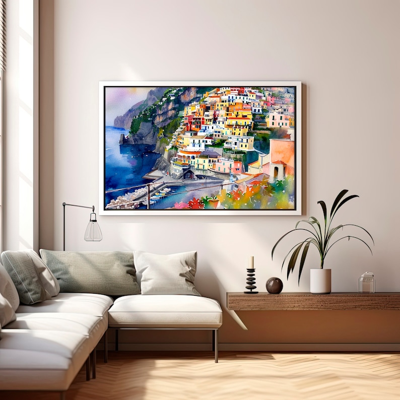 May include: A watercolour painting of a colourful Italian village built on a cliffside overlooking the ocean. The buildings are painted in shades of yellow, orange, red, and blue. The water is a deep blue, and the sky is a light blue.