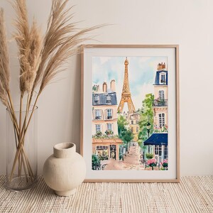 May include: A watercolour painting depicting a Parisian street scene with the Eiffel Tower in the background. The painting features buildings with balconies, trees, and a cafe with a blue awning.