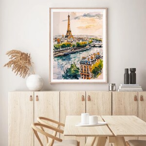 Puede incluir: Una pintura de acuarela de la Torre Eiffel en Par&iacute;s, Francia. La pintura muestra la torre desde la distancia, con el r&iacute;o Sena y otros edificios en primer plano. La pintura est&aacute; enmarcada en un marco de madera claro.