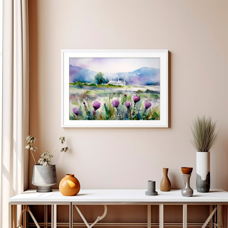 May include: Watercolor painting of a white cottage in a field of purple wildflowers with a mountain range in the background.