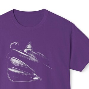May include: Purple t-shirt with a white outline of a car's front headlight and side profile.