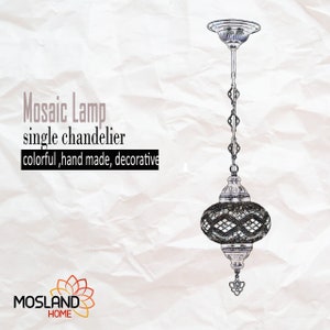 May include: A silver mosaic lamp chandelier with a chain hanging from the ceiling. The lamp has a round, glass shade with a mosaic pattern in shades of grey and white. The lamp is labelled "Mosaic Lamp single chandelier colourful, hand made, decorative".