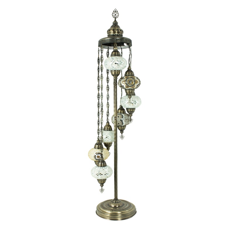 May include: A tall, ornate floor lamp with a spiral design. It features a series of six round, mosaic-tiled glass shades in white and gold tones, suspended from a chain.