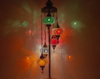 May include: A floor lamp with a twisted metal base and five colorful mosaic glass globes. The globes are lit from within, casting a warm glow.