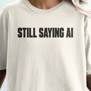 Still Saying AI T-Shirt, Sarcastic Tech Meme Typography Graphic Tee, Funny Programmer & Coder Gift, Trendy Minimalist Streetwear Shirt