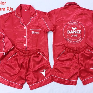 May include: Red satin pyjamas with white trim and the words "Dancer" and "Fierce Dance Mode Dance Company" printed on them.