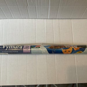 May include: A roll of Vymura International quality wallpaper wrapped in clear plastic. The label features the brand name, the text Quality Wallpaper, and a graphic illustration of a person with blonde hair wearing a blue hat and uniform.
