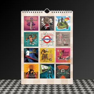 May include: A wooden-backed calendar featuring twelve colorful illustrations with chess-related themes. Each image has text, including "Giuoco Piano", "Bird's Opening", "London System", and "Queen's Gambit". The calendar is hanging against a dark background.
