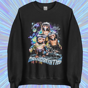 May include: Black sweatshirt with a graphic of three alien figures in helmets and holding weapons, set against a backdrop of lightning and planets. The text "DRUIDSMITHS" is displayed in a futuristic font below the creatures.