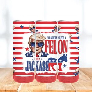 May include: Three insulated tumblers with a red, white, and blue design. Each tumbler features a portrait of a man wearing sunglasses with a star-spangled design. The text reads "I'd rather vote for a felon than a jackass."