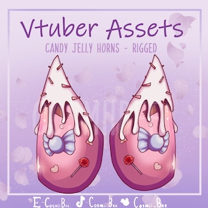 Puede incluir: Un par de cuernos de temática de caramelo rosa y blanco con un diseño de glaseado blanco, caramelo azul y blanco y un lazo rosa. Los cuernos están diseñados para su uso en realidad virtual.