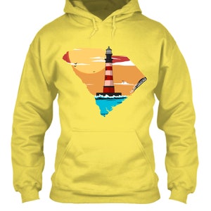 May include: Yellow hoodie with a graphic of a lighthouse in front of a sunset and the outline of South Carolina. The text "SOUTH CAROLINA" is on the graphic.