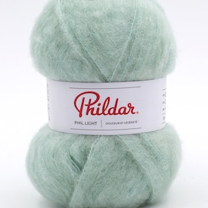 May include: A ball of light green Phil Light yarn by Phildar. The label reads "Phil Light Douceur et Legereté".