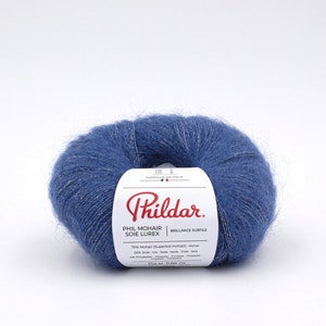 Op de afbeelding: Een bol blauwe garen met een gouden draad die er doorheen loopt. Het etiket vermeldt "Phil Mohair Soie Lurex" en "Brilliance Subtile". De garen is 70% mohair, 20% zijde en 10% polyester.