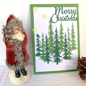 Vrolijke kerstkaart met reliëf.  Gestanste kerstkaart met reliëf en boomkwekerij. 5" x 7" - blanco binnenkant en geleverd met envelop.