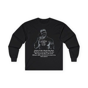 Peut inclure: T-shirt noir à manches longues avec un dessin blanc d'un homme tenant une tasse à café. Le dessin comprend le texte "Muscles Yum Made" et un conseil de vie. Le t-shirt est fait d'une matière douce et confortable.