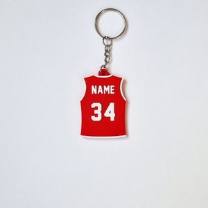 Puede incluir: Llavero de camiseta de baloncesto roja y blanca con el texto "NAME" y el número "34" impreso en la parte posterior.