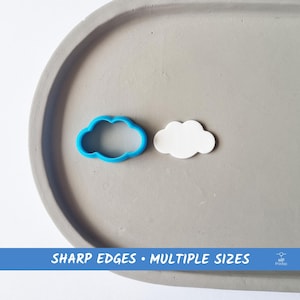 Puede incluir: Un cortador de galletas de nube de plástico azul y una nube blanca hecha de arcilla polimérica. El texto "SHARP EDGES - MULTIPLE SIZES" está impreso debajo de la imagen.