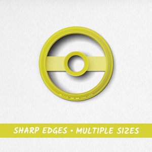Puede incluir: Cortador de galletas de plástico amarillo en forma de círculo con un círculo más pequeño en el interior y una línea horizontal en el centro.