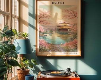 Puede incluir: Un póster enmarcado de Kioto, Japón, con un templo dorado reflejado en un lago, rodeado de flores de cerezo. El póster está en un marco de madera en una pared verde azulado. Un tocadiscos naranja está debajo.
