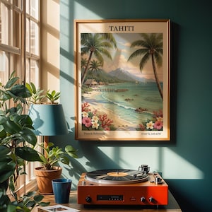 Può includere: Una stampa incorniciata di Tahiti con una scena di spiaggia, palme e una montagna sullo sfondo. La stampa è appesa a una parete turchese sopra un giradischi arancione. Una lampada blu e delle piante sono in primo piano.