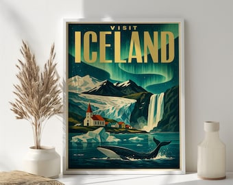 May include: A framed travel poster featuring the text VISIT ICELAND in gold letters. The illustration depicts a dark blue night sky with green aurora borealis, snow-capped mountains, a waterfall, a small village, and a whale in the water.