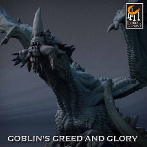 Peut inclure: Une figurine de dragon imprimée en 3D, détaillée, de couleur grise, avec une corne pointue et un corps texturé et écailleux. Le dragon tient une petite figurine dans sa gueule. Le texte "Goblin's Greed and Glory" est imprimé sous le dragon.