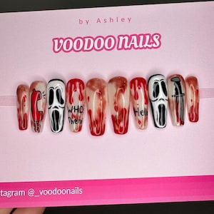 May include: Set of fake nails with a Halloween theme. The nails are white with red blood dripping down them. Some nails have a ghost face with a phone and the words "Who's there" and "Hello". One nail has a knife.
