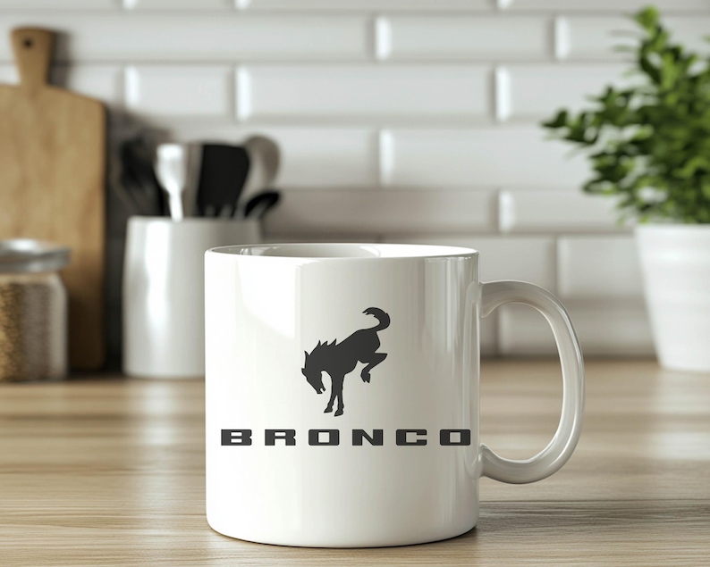 May include: White ceramic mug with a black silhouette of a horse and the word "BRONCO" printed on it.