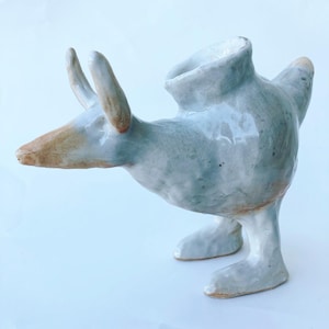 Handmade ceramic horned creature sculpture based on prehistoric baby bottles