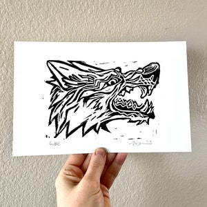 Könnte beinhalten: Schwarz-weiß-Druck eines Wolfskopfes mit wütendem Ausdruck. Der Druck ist mit 6/6 nummeriert.