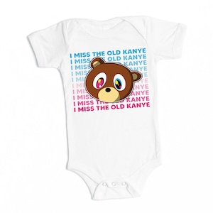 May include: White babygrow with a cartoon bear face and the text "I Miss The Old Kanye" repeated in a gradient of blue, pink, and white.