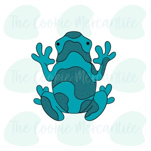 Puede incluir: Un cortador de galletas de rana azul con un patrón moteado. El cortador de galletas está diseñado para cortar una forma de rana.